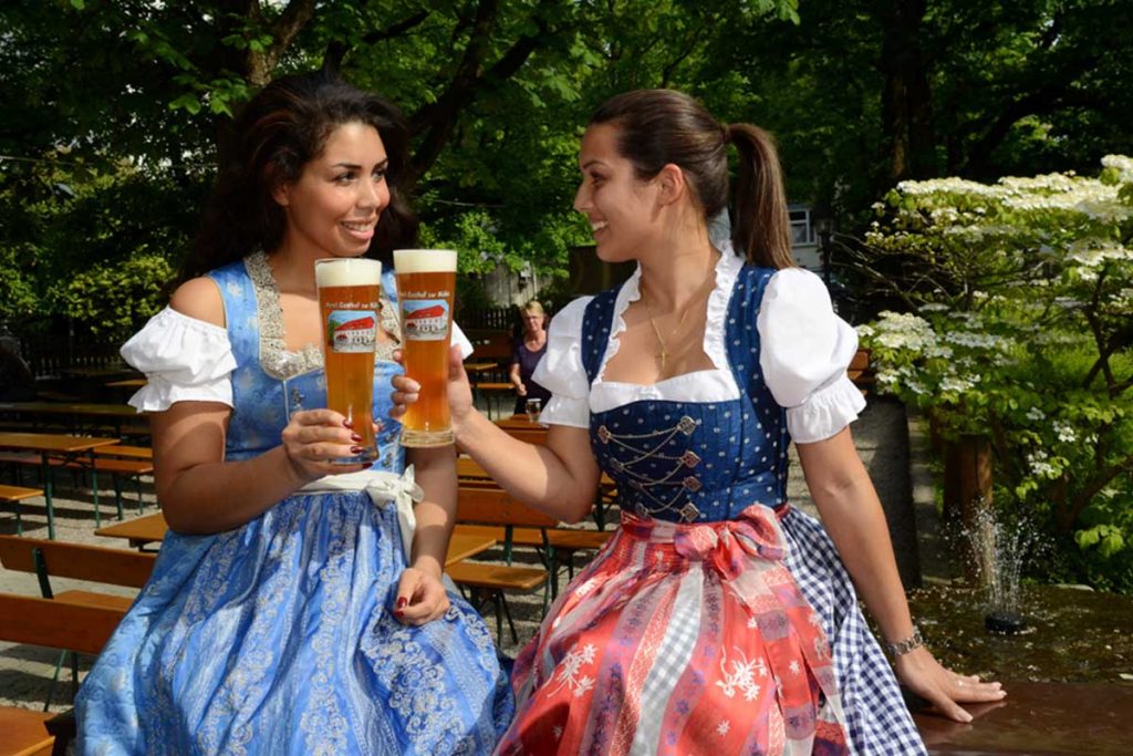 Frauen in Tracht stossen mit Bier an